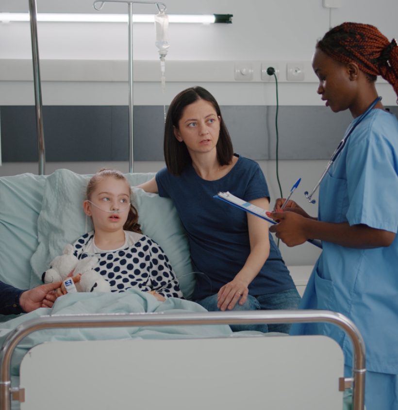 African american pediatric nurse explaining recovery treatment to worried parents monitoring sickness symptoms. Sick girl patient lying in bed wearing oxygen nasal tube having breathing disease
