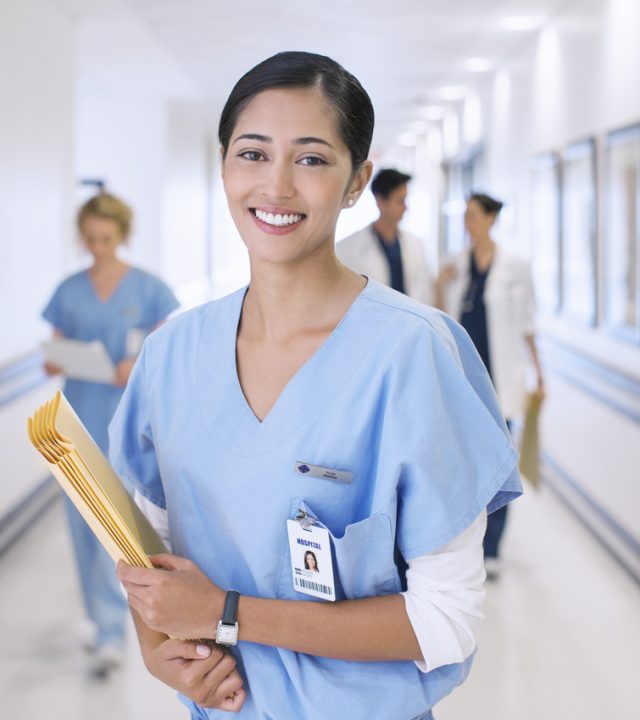 Portrait of smiling nurse in hospital corridor